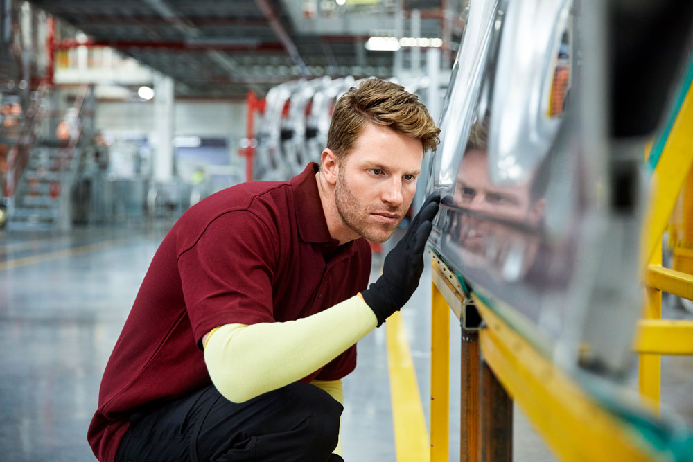 Man Inspects Vehicle Part