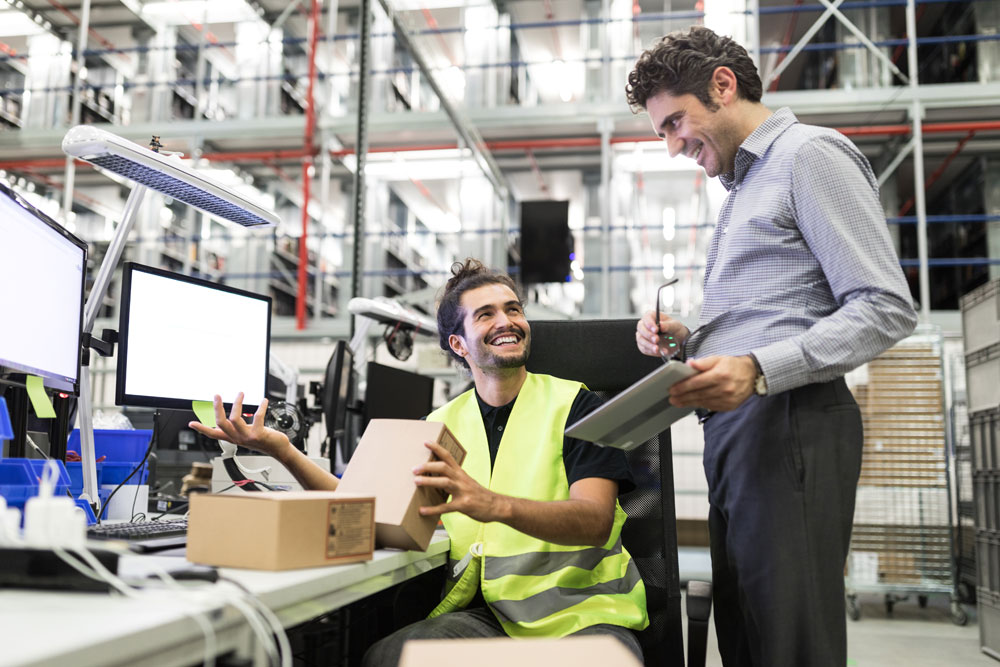 Men In Warehouse Office With Parts Stock